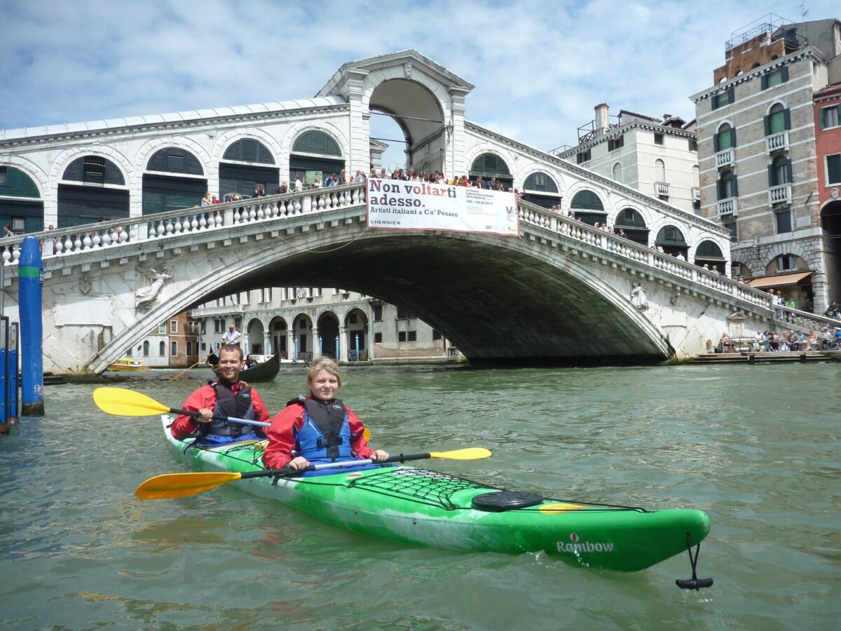 Couple in double kayak in front of the Rialto Bridge (press photo)