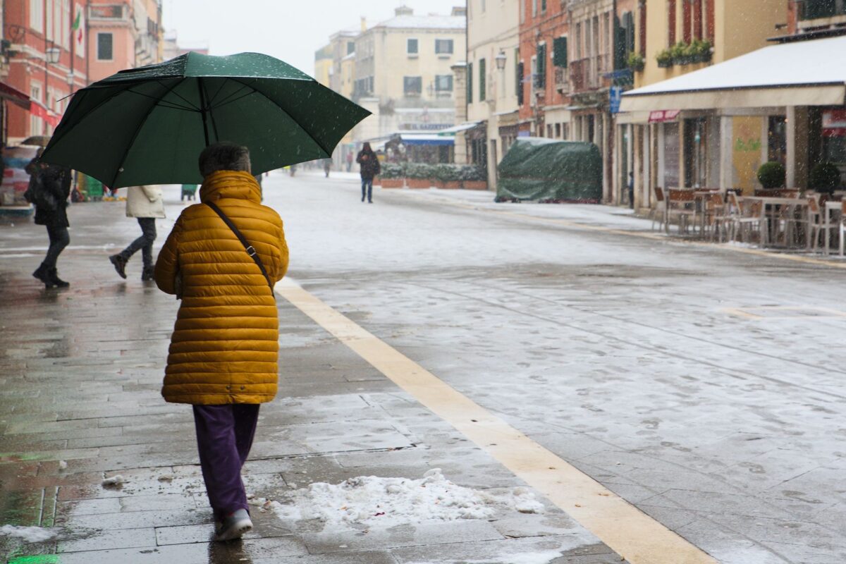 Woman walking in Via Garibaldi in Venice in the snow