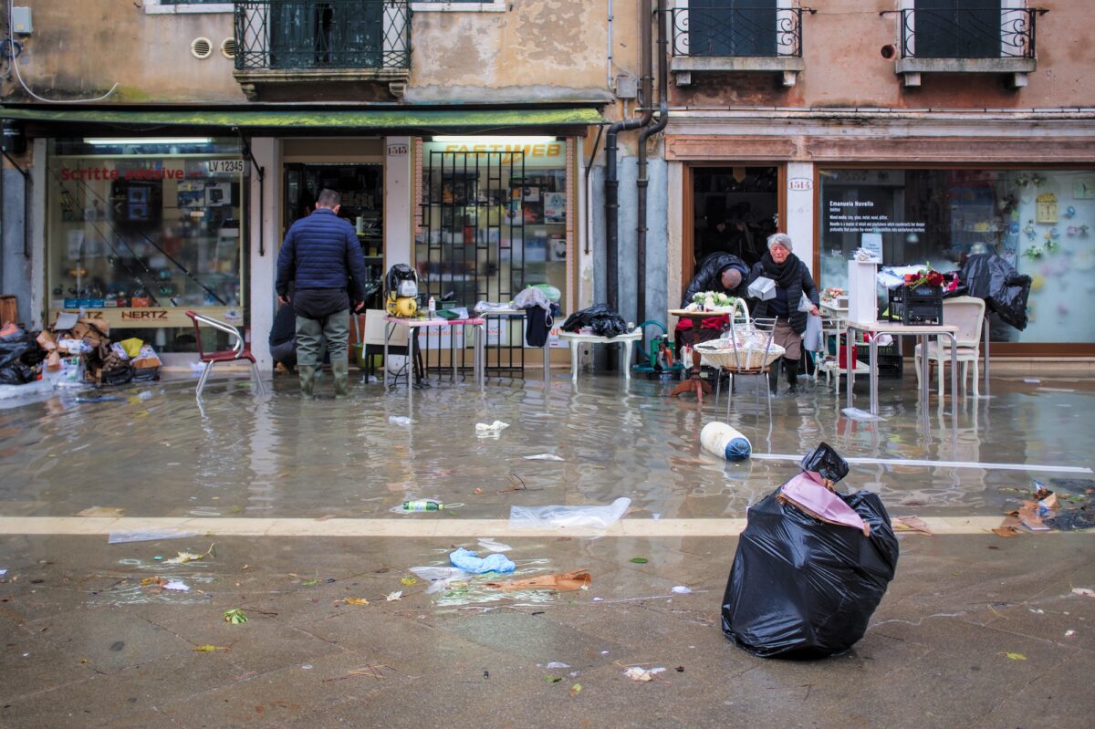 High tide in Venice - shopkeepers trying to clean up